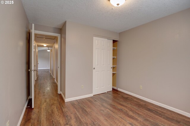 640 Sherman Dr, The Dalles, OR 97058 - unfurnished bedroom with wood finished floors, a textured ceiling, a closet, and baseboards