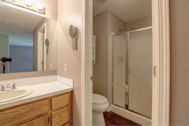 640 Sherman Dr, The Dalles, OR 97058 - bathroom featuring a textured ceiling, a shower stall, wood finished floors, vanity, and toilet