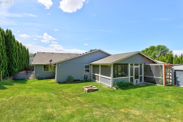 640 Sherman Dr, The Dalles, OR 97058 - back of house featuring a sunroom, a lawn, an outdoor fire pit, and a shingled roof
