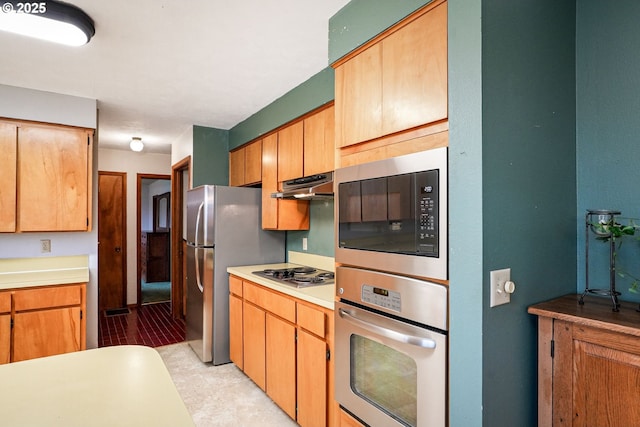 kitchen with under cabinet range hood, stainless steel appliances, and light countertops