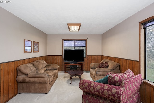 carpeted living room with a wainscoted wall and wood walls