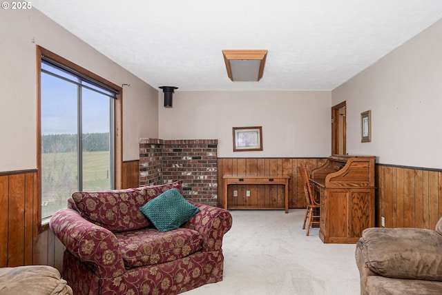 sitting room with carpet, wood walls, and wainscoting