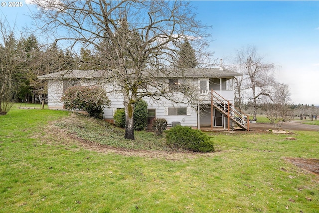 back of house with a yard and stairs