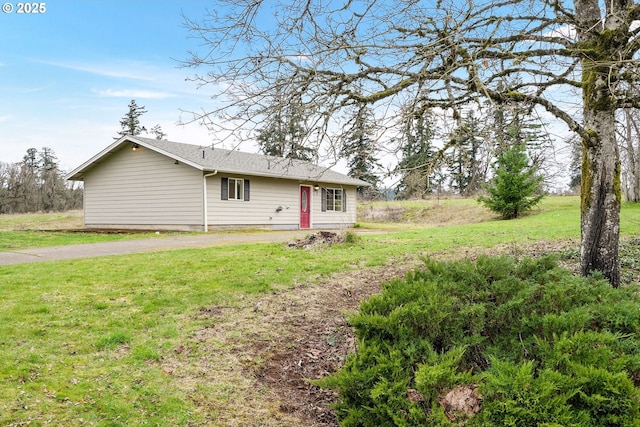 exterior space featuring aphalt driveway and a yard