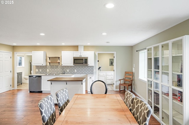 dining space featuring a healthy amount of sunlight, baseboards, wood finished floors, and recessed lighting