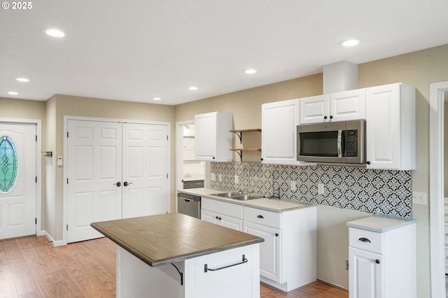 kitchen with recessed lighting, white cabinetry, appliances with stainless steel finishes, light wood finished floors, and tasteful backsplash