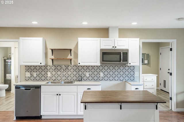 kitchen featuring appliances with stainless steel finishes, white cabinets, butcher block countertops, and a sink