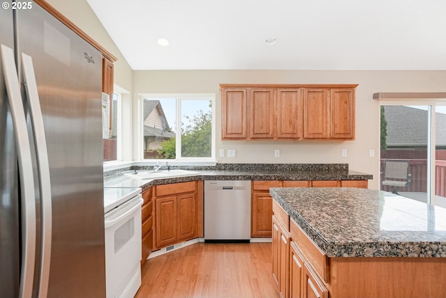 967 Whippoorwill Ct NW, Salem, OR 97304 - kitchen with appliances with stainless steel finishes, light wood-type flooring, dark countertops, brown cabinets, and lofted ceiling