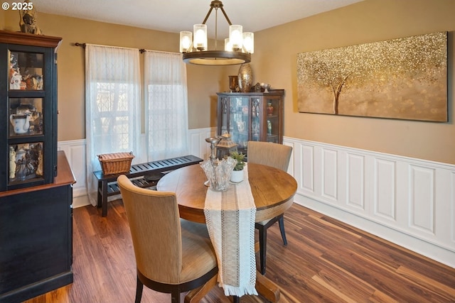 dining space with dark hardwood / wood-style flooring and a chandelier