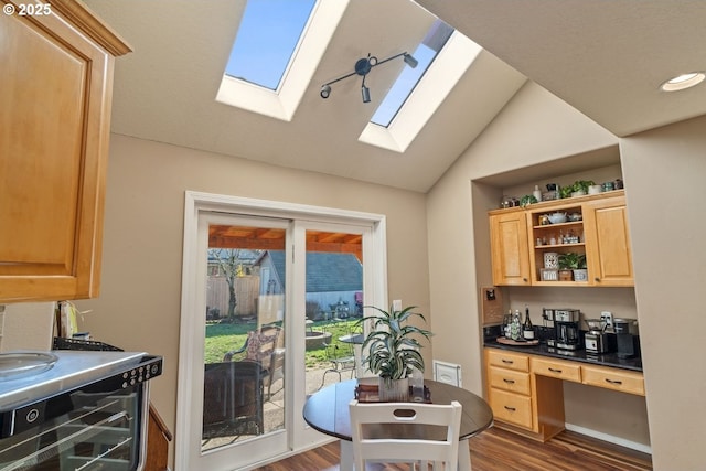 kitchen with light brown cabinetry, wine cooler, vaulted ceiling, and wood-type flooring