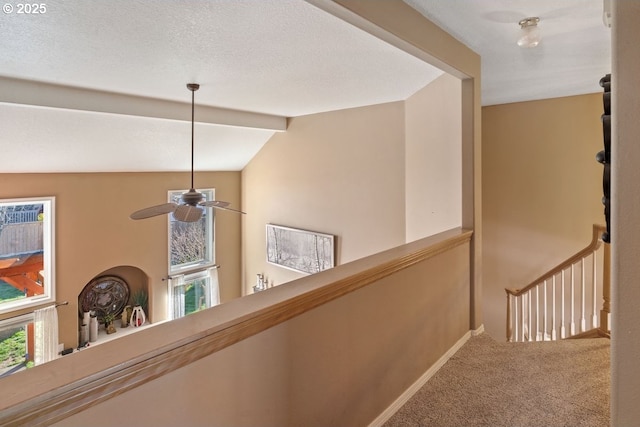 hallway with vaulted ceiling with beams, carpet floors, and a healthy amount of sunlight