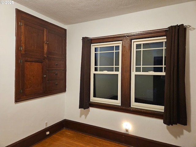 room details featuring hardwood / wood-style flooring and a textured ceiling