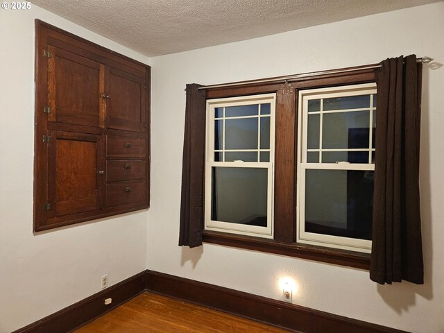 bedroom with dark wood-type flooring and a textured ceiling