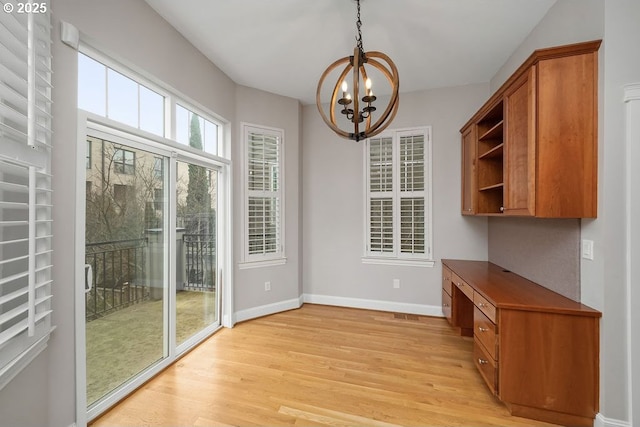 unfurnished dining area featuring light hardwood / wood-style floors and an inviting chandelier