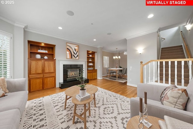 living room with built in features, light hardwood / wood-style flooring, and ornamental molding