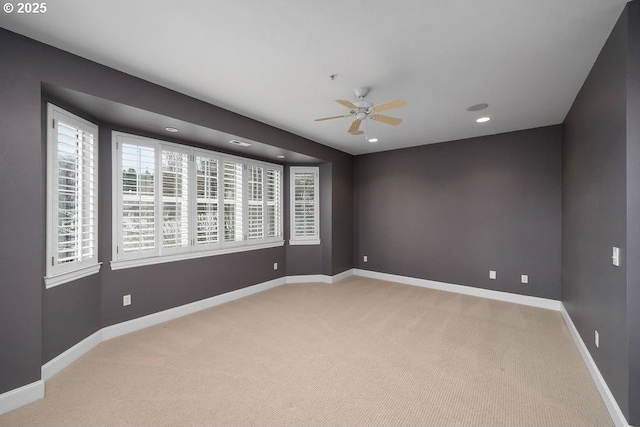 spare room featuring ceiling fan and light colored carpet