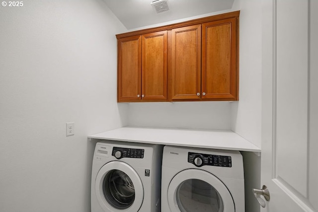 clothes washing area featuring cabinets and independent washer and dryer