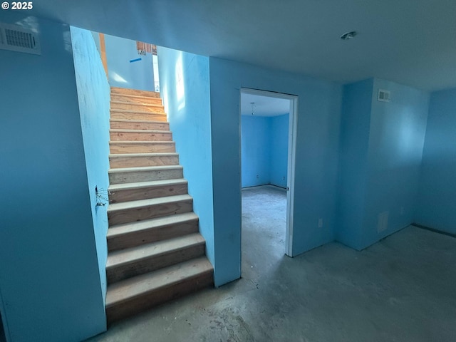 stairs featuring visible vents and unfinished concrete floors