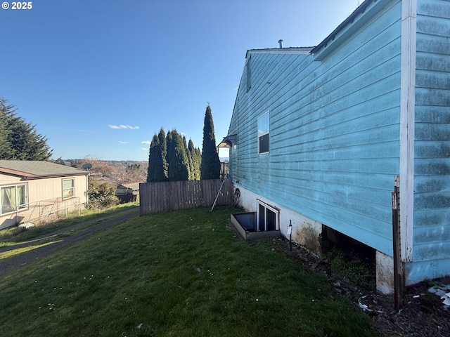 view of property exterior with a lawn and fence