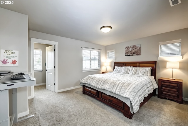 bedroom featuring light carpet, multiple windows, and baseboards