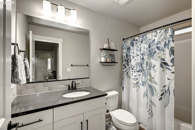 bathroom featuring toilet, vanity, and shower / bath combo