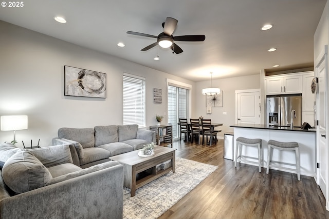 living area with a ceiling fan, recessed lighting, and dark wood-style floors