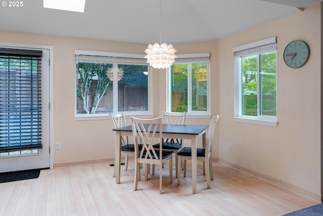 13465 SW Lancewood St, Beaverton, OR 97008 - dining area featuring wood finished floors, a chandelier, baseboards, and a skylight