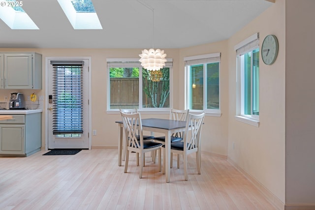 13465 SW Lancewood St, Beaverton, OR 97008 - dining room featuring light wood-style floors, a skylight, baseboards, and a chandelier