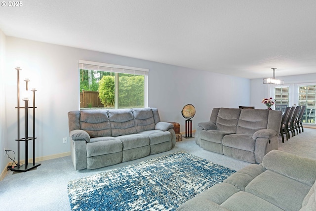13465 SW Lancewood St, Beaverton, OR 97008 - carpeted living room featuring a chandelier and baseboards