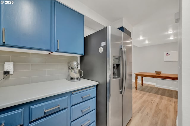 103 Treehill Loop, Eugene, OR 97405 - kitchen with stainless steel refrigerator with ice dispenser, blue cabinetry, backsplash, and light countertops