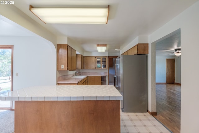30563 Fairview Rd, Lebanon, OR 97355 - kitchen featuring freestanding refrigerator, brown cabinetry, light floors, and a sink