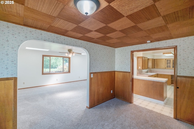 30563 Fairview Rd, Lebanon, OR 97355 - empty room with arched walkways, wainscoting, wallpapered walls, a sink, and wooden walls