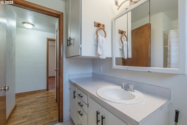 30563 Fairview Rd, Lebanon, OR 97355 - full bathroom with vanity, wood finished floors, and baseboards