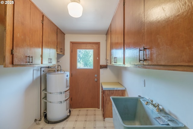30563 Fairview Rd, Lebanon, OR 97355 - laundry room featuring strapped water heater, cabinet space, and light flooring