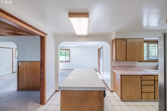 30563 Fairview Rd, Lebanon, OR 97355 - kitchen with arched walkways, light floors, a kitchen island, and brown cabinets