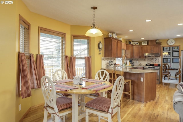 dining area with light wood-type flooring and recessed lighting