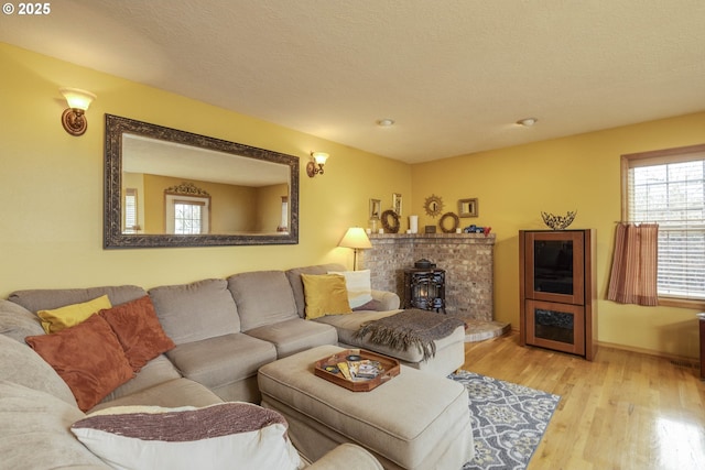 living room featuring a textured ceiling, baseboards, and wood finished floors