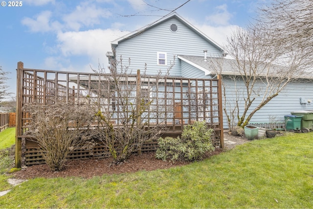 back of property with a yard and a wooden deck