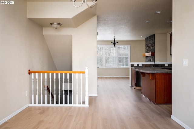 kitchen with a textured ceiling, baseboards, and wood finished floors