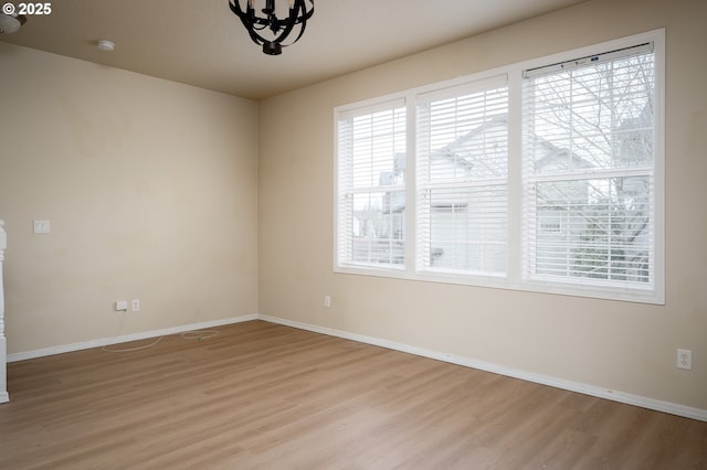 empty room with light wood finished floors and baseboards