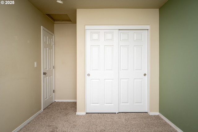 unfurnished bedroom featuring a closet, baseboards, and carpet flooring