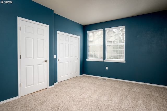 unfurnished bedroom featuring a closet, carpet flooring, and baseboards