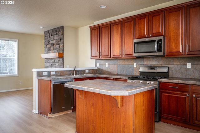 kitchen featuring tasteful backsplash, stainless steel appliances, a sink, and a center island