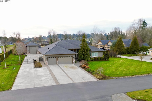 view of front facade with driveway, a residential view, an attached garage, fence, and a front lawn