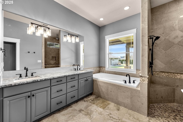 full bathroom featuring a bath, double vanity, a tile shower, and a sink