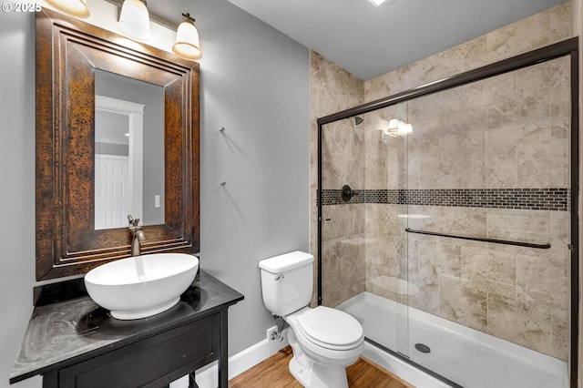 full bath with toilet, wood finished floors, a shower stall, and vanity