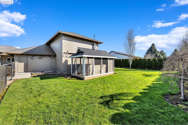 back of property featuring a shingled roof, a sunroom, fence, and a lawn