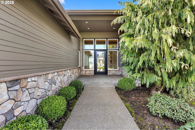 entrance to property featuring covered porch and stone siding