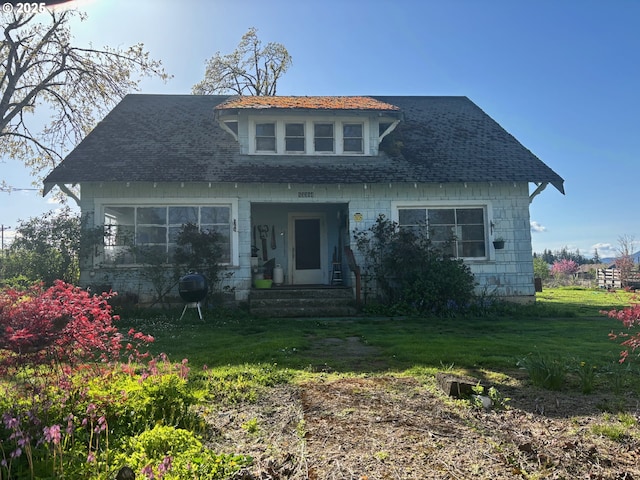 bungalow with roof with shingles and a front lawn