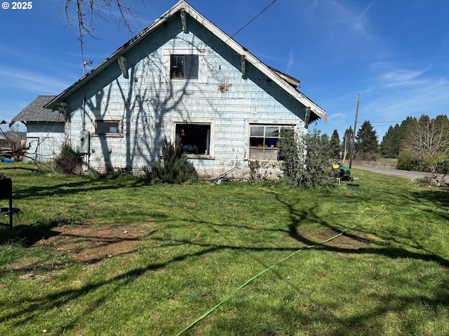 rear view of house featuring a lawn